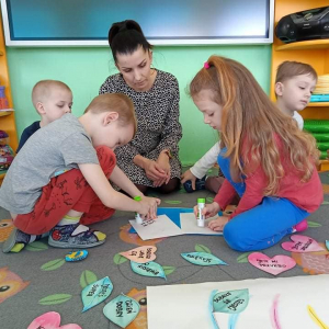 Dziewczynka z chłopcem smarują klejem karteczki