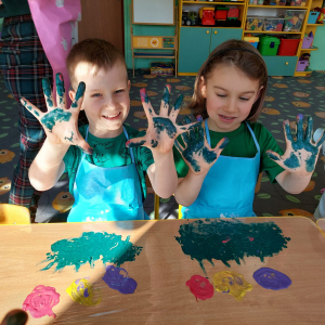 Chłopcy mają pomalowane ręce farbą.