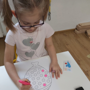 Dziewczynka maluje balona wg. kodu kolorów flamastrami fluorescencyjnymi.