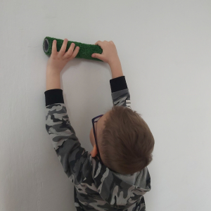 Chłopiec toczy po ścianie wałek.