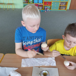 Chłopcy ozdabiają jajka metodą batikową (pisanie woskiem)