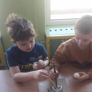 Chłopcy ozdabiają jajka metodą batikową (pisanie woskiem)