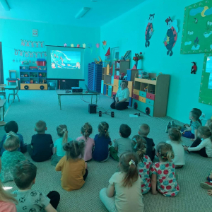 Dzieci oglądają film edukacyjny pt. Jak dbać o naszą Planetę.