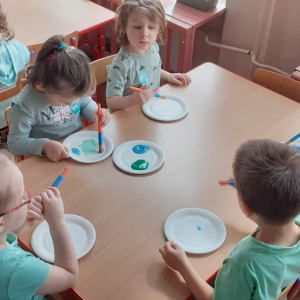 Dzieci maluja farbami Ziemię