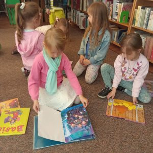Dzieci przeglądają książeczki w bibliotece