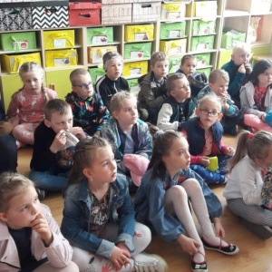 Dzieci siedzące w klasie na podłodze