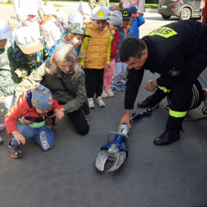 Strażak pokazuje dzieciom sprzęt strażacki