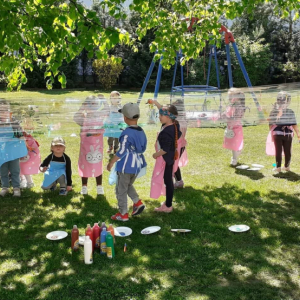 Grupa Muchomorki malują na placu pędzelkami na folii