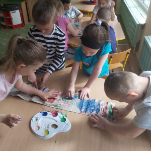 Dzieci malują paluszkami farbą po falistej tekturce