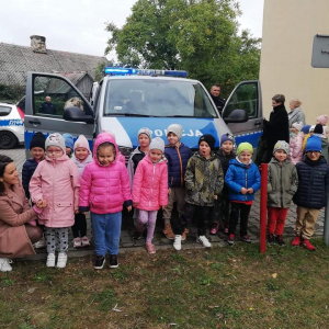 Dzieci z grupy Jagódki stoją przed radiowozem