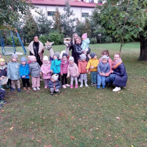 Dzieci z grupy Biedroneczki wraz z paniami, alpakami i ich opiekunkami pozują do pamiątkowego zdjęcia 