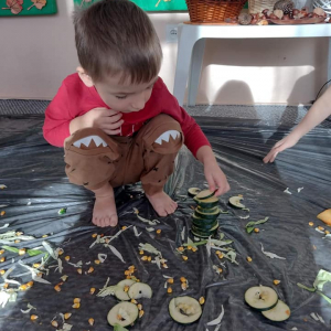 Chłopiec układa wieżę z pokrojonej na plasterki cukinii 