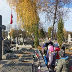 Dzieci stoją przed grobami