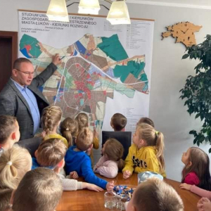 Burmistrz miasta pokazuje dzieciom mapę 