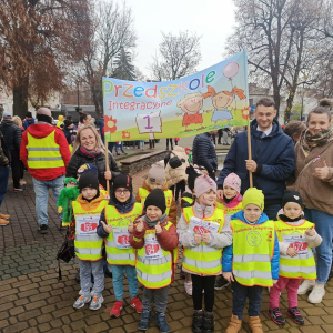 Dzieci z paniami stoją z transparentem przedszkola