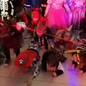 Dzieci czołgają się pod liną