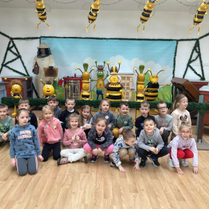 Dzieci stoją na tle pszczół
