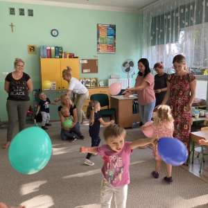 Wspólna zabawa rodziców i dzieci z balonami.