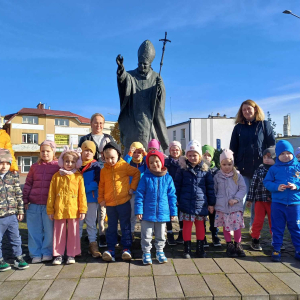 Zdjęcie grupowe dzieci i pań przy pomniku Papieża Jana Pawła II