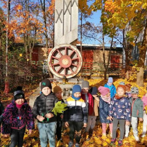Dzieci stoją przy pomniku Kolejarzy