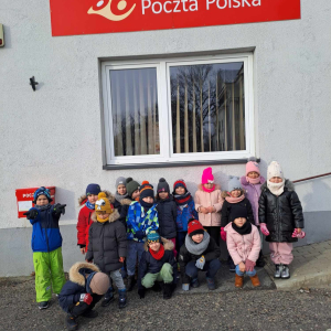 Dzieci stoją przed budynkiem urzędy pocztowego