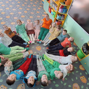 Dzieci z kolorowymi skarpetkami siedzą na dywanie