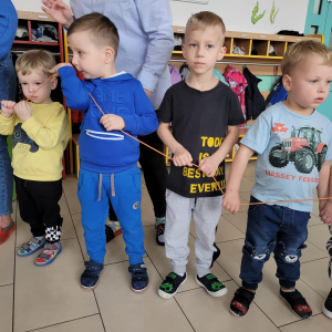 Dzieci stoją i trzymają sznurek