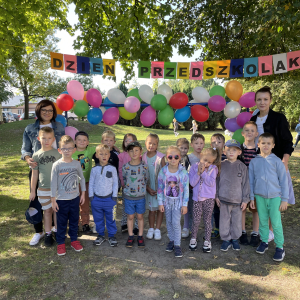 zdjęcie grupowe na tle dekoracji z okazji Dnia Przedszkolaka