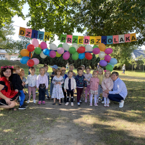 zdjęcie grupowe na tle dekoracji z okazji Dnia Przedszkolaka