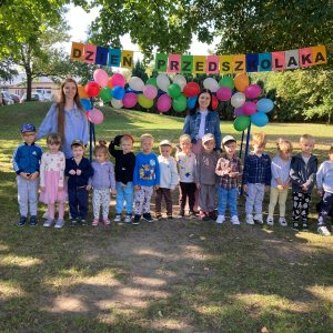 zdjęcie grupowe na tle dekoracji z okazji Dnia Przedszkolaka