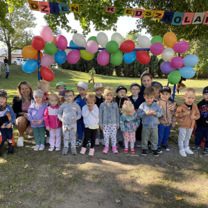 zdjęcie grupowe na tle dekoracji z okazji Dnia Przedszkolaka