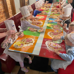 Dzieci robią pizzę na warsztatach robienia pizzy w pizzerii.