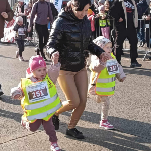 Pani trzyma dzieci za ręce i biegną