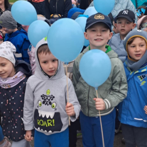 Dzieci stoją z balonami.