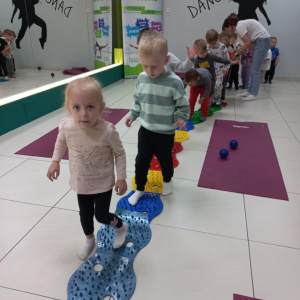 Dzieci idą po ścieżce sensorycznej