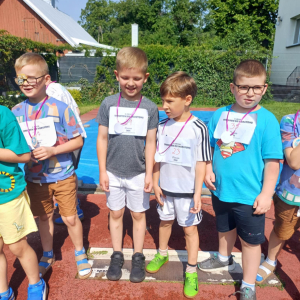 Dzieci po ukończonym biegu z medalami.