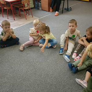 Dzieci siedzą na dywanie