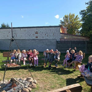 Dzieci siedzą w koło ogniska