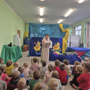 Dzieci siedzą i oglądają aktorów na scenie