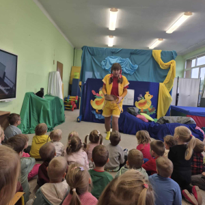 Dzieci siedzą i oglądają aktorów na scenie
