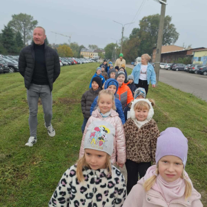 Dzieci z tatą Natalki idą chodnikiem w strone fabryki.