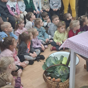 Dzieci w muzeum obserwują jak sie kisi kapustę