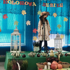 Dziewczynka stoi na scenie i śpiewa piosenkę.