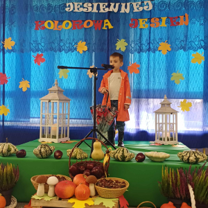 Chłopiec stoi na scenie i śpiewa piosenkę.