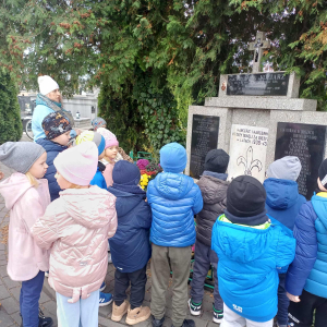 Dzieci stoją przed grobem Harcerzy.