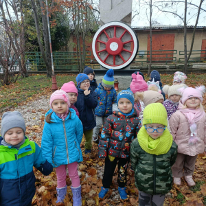 Dzieci stoją przed Pomnikiem Kolejarza