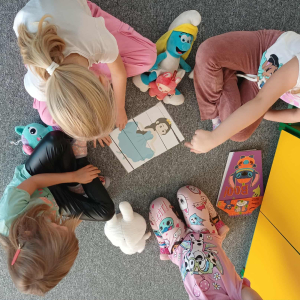 Dziewczynki układaja puzzle z księżniczką.