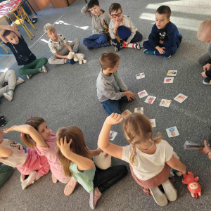 Dzieci siedzą w kole i bawią się w zabawe