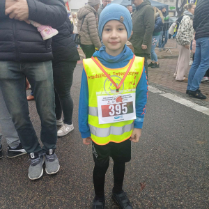 Chłopiec pozuje do zdjęcia z medalem,