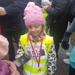 Dziewczynka pozuje do zdjęcia z medalem